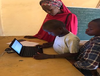 Image 5: Students being taught computer basics